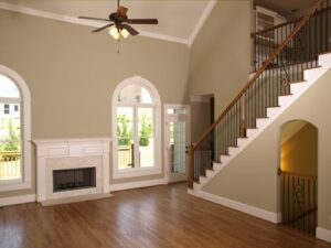 interior of spacious living room with fireplace, staircase, and new paint